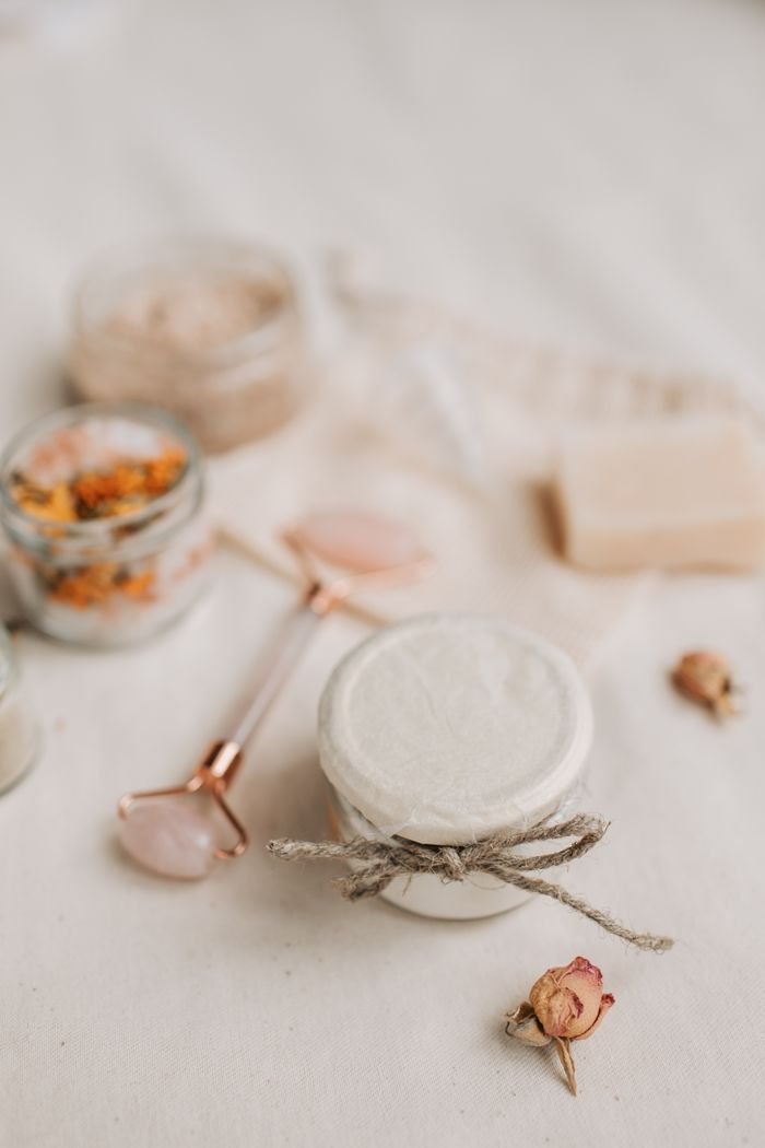 A serene arrangement of skincare products and a jade roller for a calm and elegant spa ambiance.